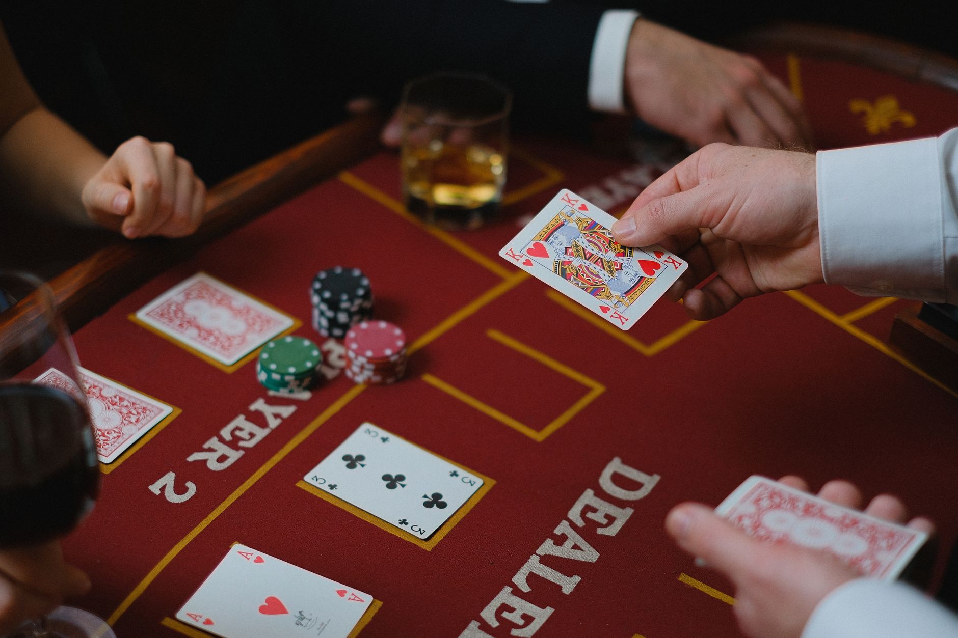 Gros plan sur un jeu de casino avec des cartes et des jetons sur la table, montrant l'interaction du joueur.